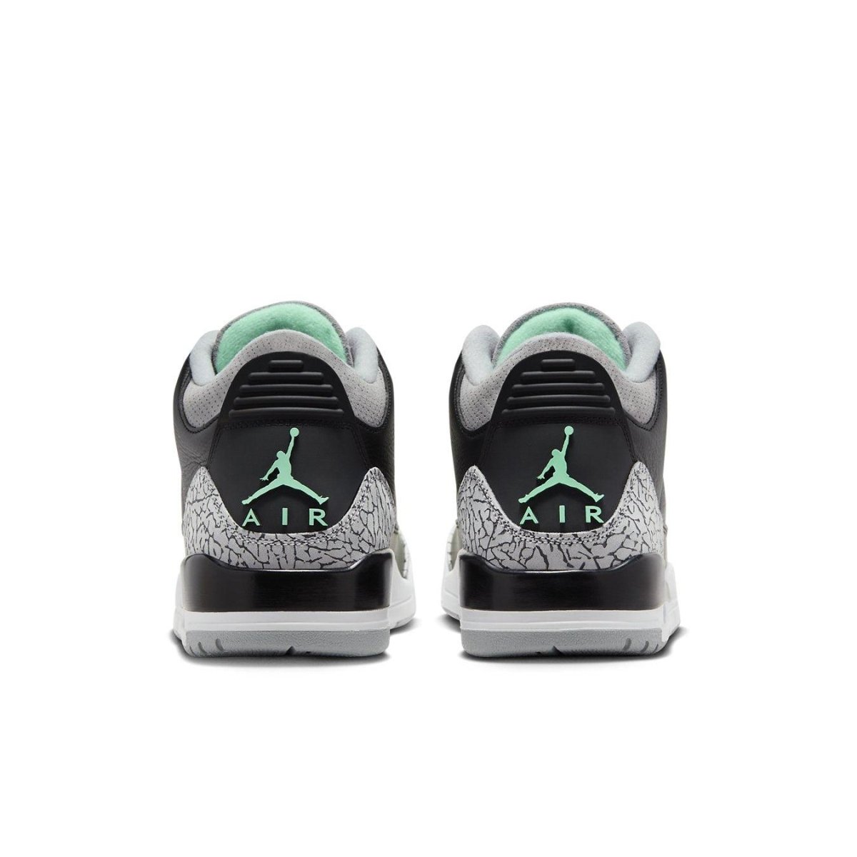 Rear view of Jordan 3 Retro Green Glow sneakers showcasing black leather and green accents.