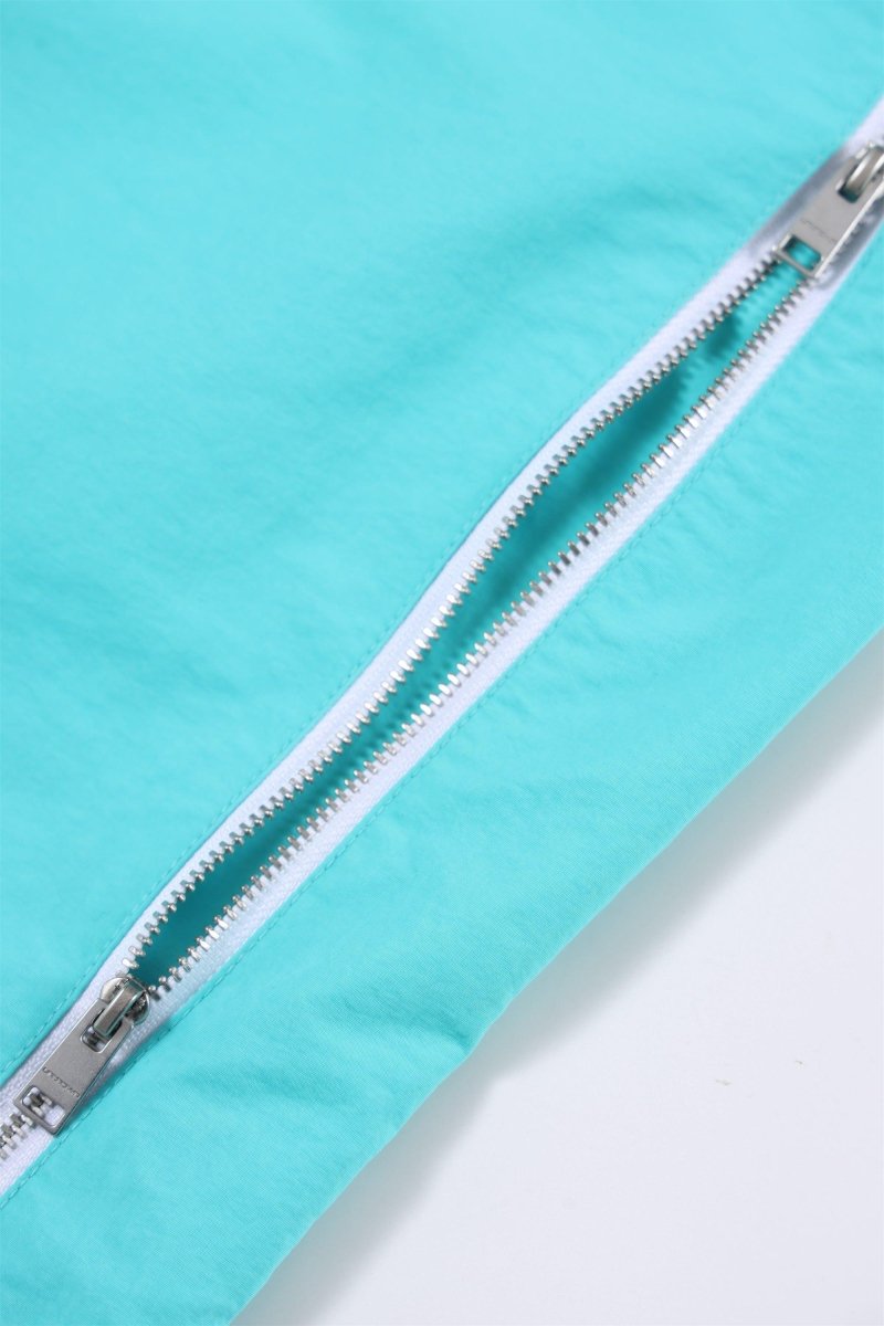 Close-up of mint green zip detail on Simba La Rue track pants, showcasing high-quality zipper and fabric texture.