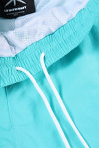 Close-up of mint and white Unknown x Simba La Rue zip track pants with elastic waistband and drawstring detail.