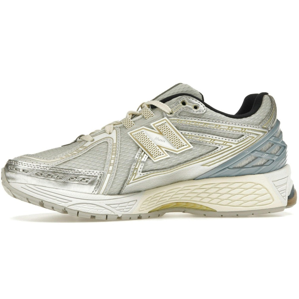 New Balance 1906R Kith sneaker in white, featuring breathable mesh and metallic silver overlays, accented with gold.