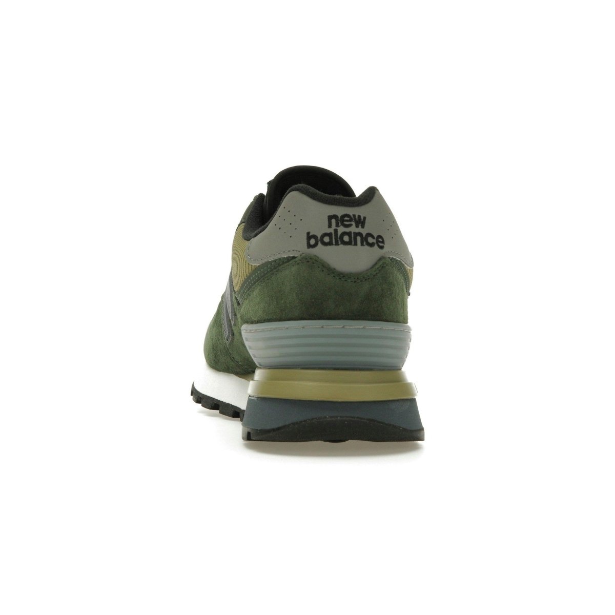 Back view of New Balance 574 Legacy Stone Island sneaker in dark green, showcasing logo and suede details.