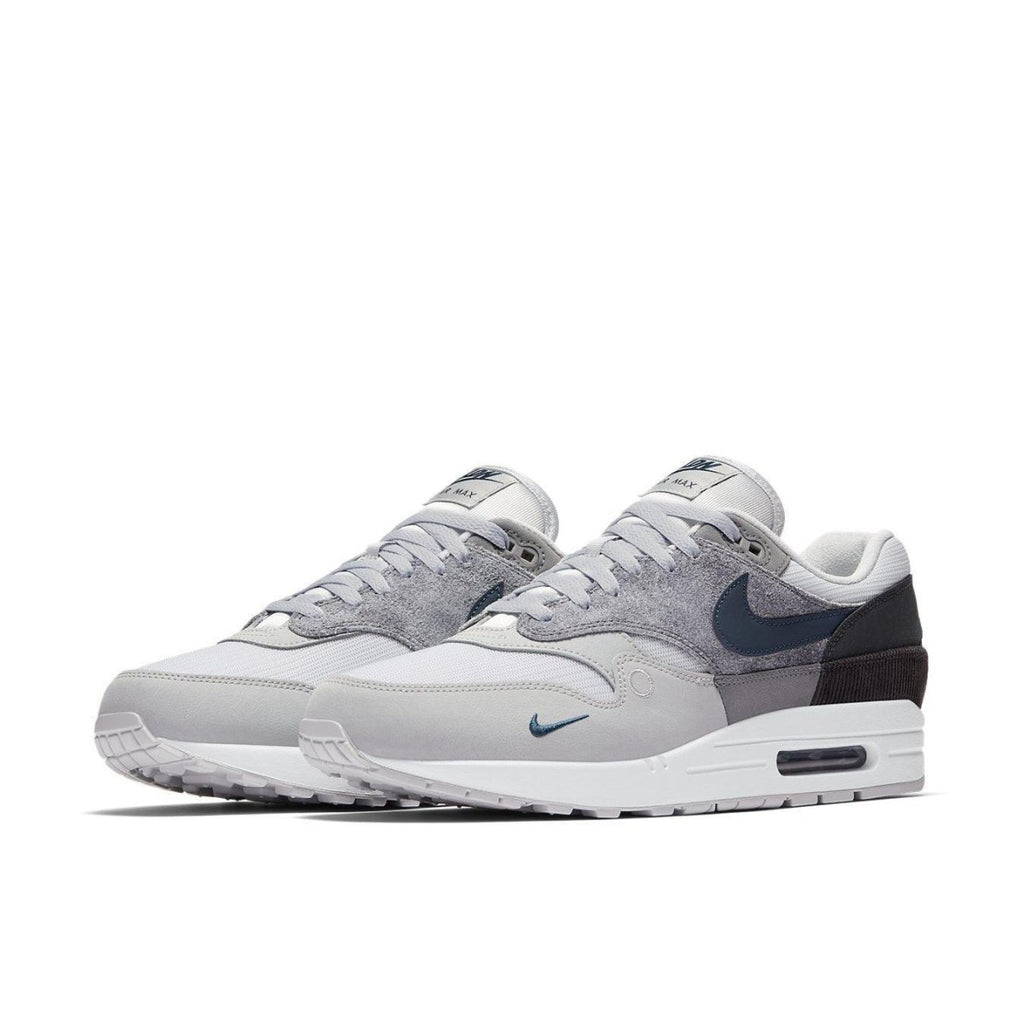Nike Air Max 1 London sneakers in gray and blue, showcasing a blend of textures and urban design.