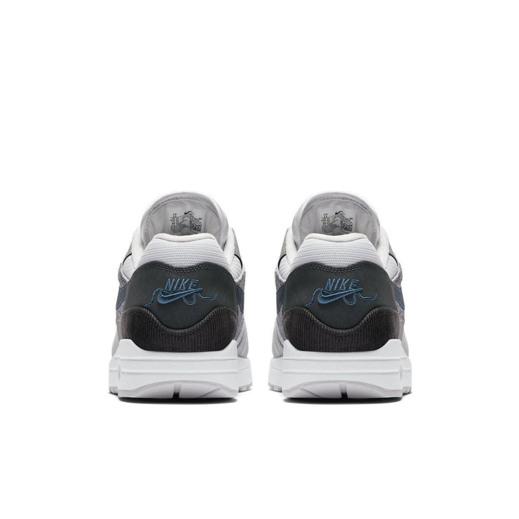 Nike Air Max 1 London sneakers in grey and black with blue logo, showcasing urban design elements.