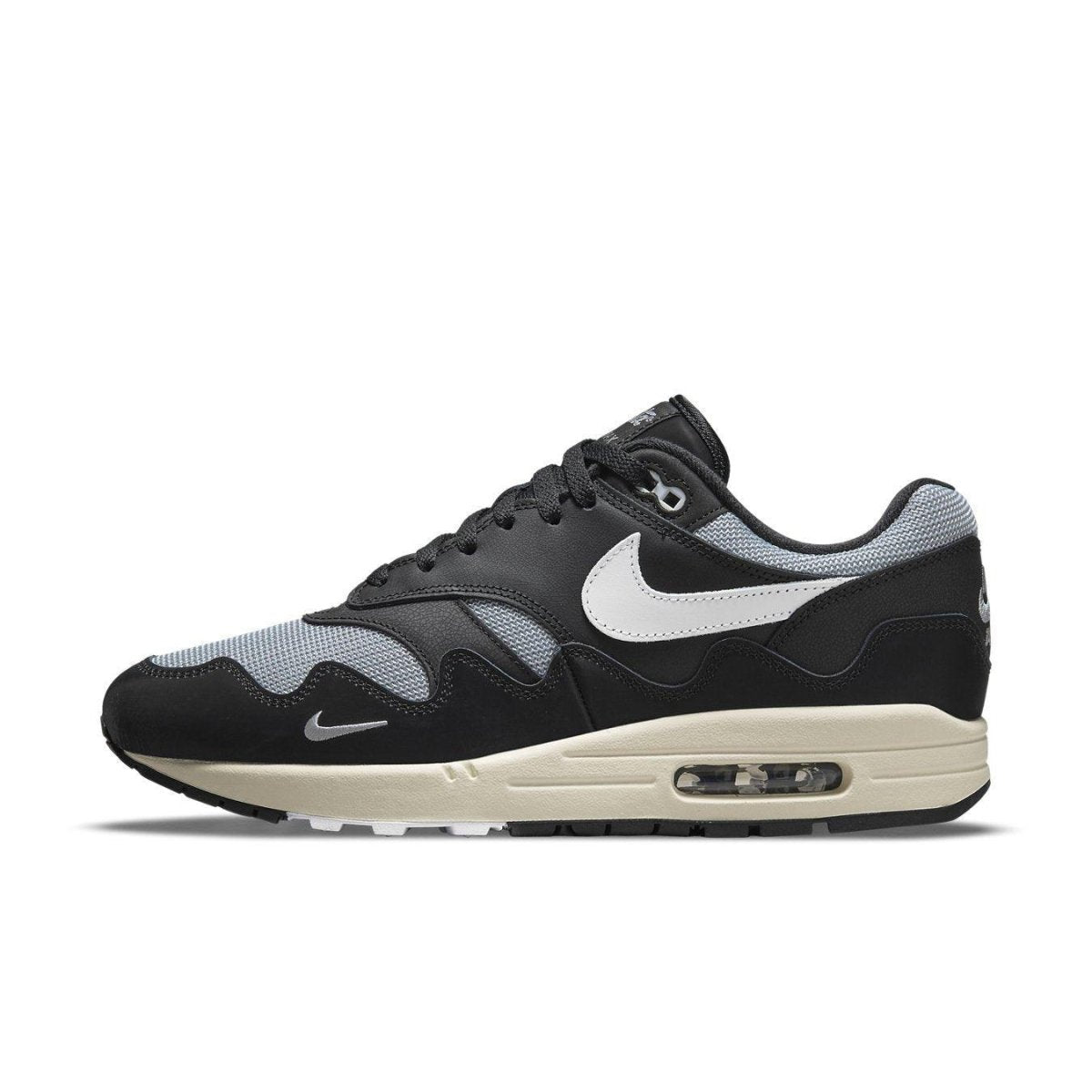 Nike Air Max 1 Patta Waves Black sneakers with mesh and synthetic leather upper, featuring a unique wave design and mini-swoosh.