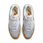 Nike Air Max 1 Patta Waves Monarch sneakers in white and orange, featuring Patta logo and unique wave design.
