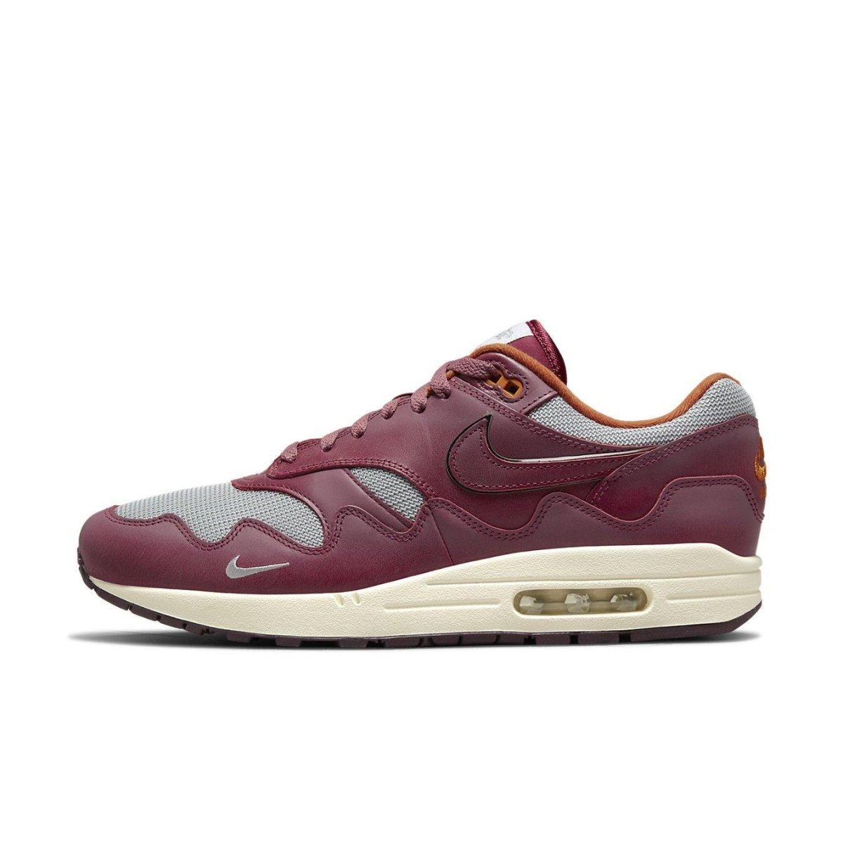 Nike Air Max 1 Patta Waves in Rush Maroon with gray mesh and smooth brown leather overlays, featuring a yellowed sole.