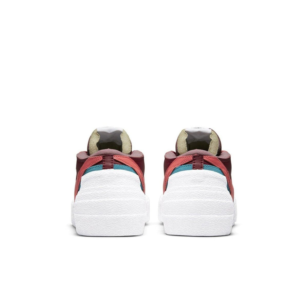 Back view of Nike Blazer Low sacai KAWS Red sneakers featuring dark red leather and contrasting color detailing.