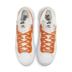 Nike Blazer Low sacai in White and Magma Orange, featuring layered Swooshes and unique double lacing design.