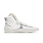 Nike Blazer Mid sacai in white and grey, featuring dual Swoosh design and high-top silhouette.