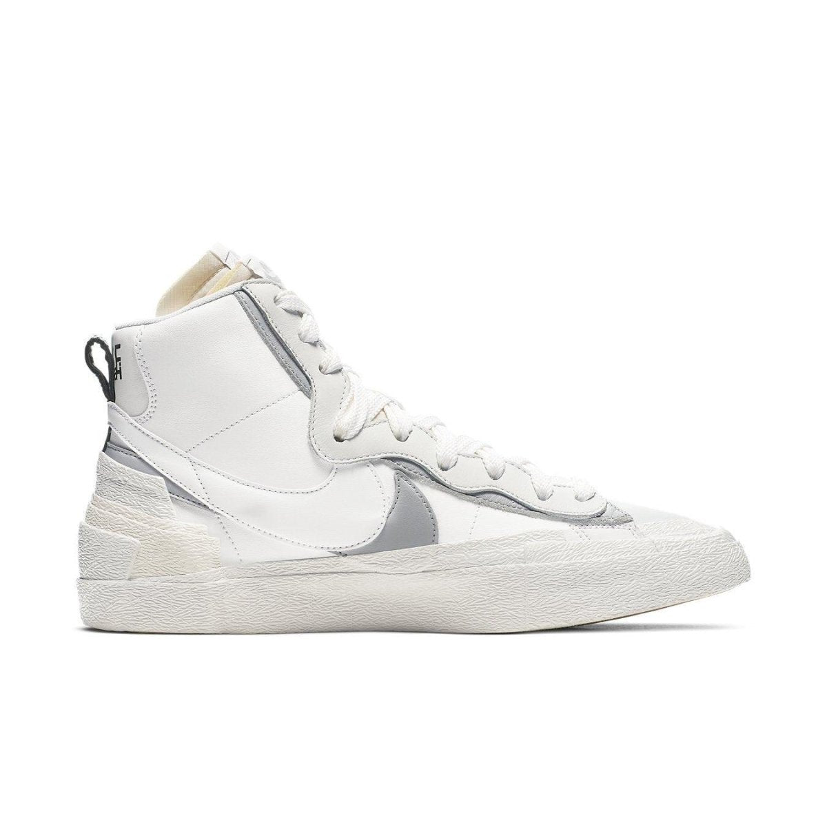 Nike Blazer Mid sacai in white and grey, featuring dual Swoosh design and high-top silhouette.