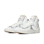 Nike Blazer Mid sacai in white and grey, featuring dual Swoosh design and classic high-top silhouette.