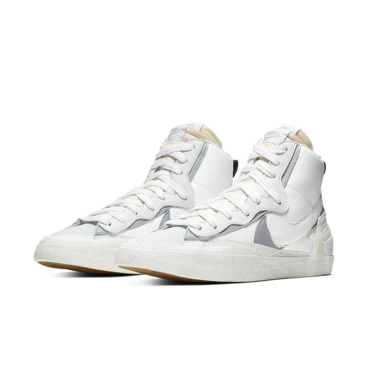 Nike Blazer Mid sacai in white and grey, featuring dual Swoosh design and classic high-top silhouette.