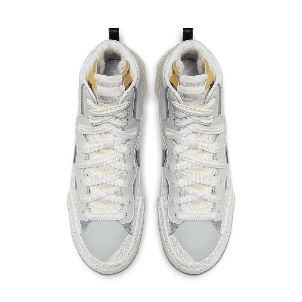 Nike Blazer Mid sacai in white and grey, featuring double Swoosh design and unique lace-up style from above.