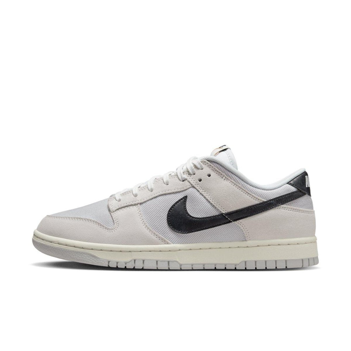 Nike Dunk Low Certified Fresh sneaker in beige and white, featuring black Swoosh and mesh panels.