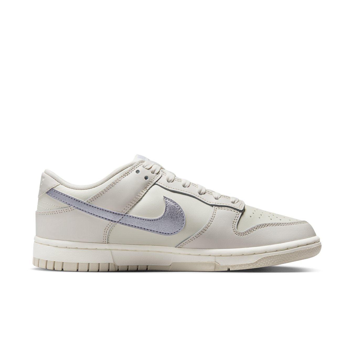 Nike Dunk Low ESS Sail Oxygen Purple women’s sneakers featuring white premium leather and metallic purple Swoosh.