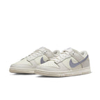 Nike Dunk Low ESS Sail Oxygen Purple women's sneakers featuring premium white leather and metallic purple Swoosh.