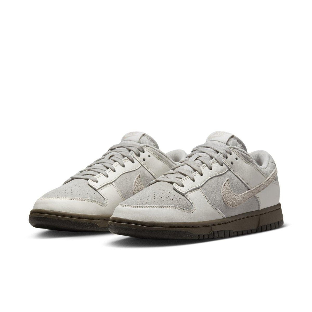 Nike Dunk Low Ironstone sneakers featuring a light upper and chocolate outsole for a stylish look.