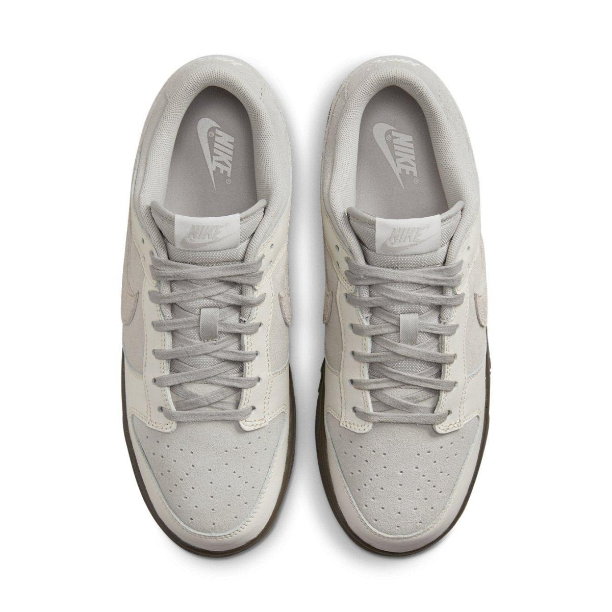 Nike Dunk Low Ironstone sneakers in light gray with dark sole, showcasing a sleek and modern design from above.
