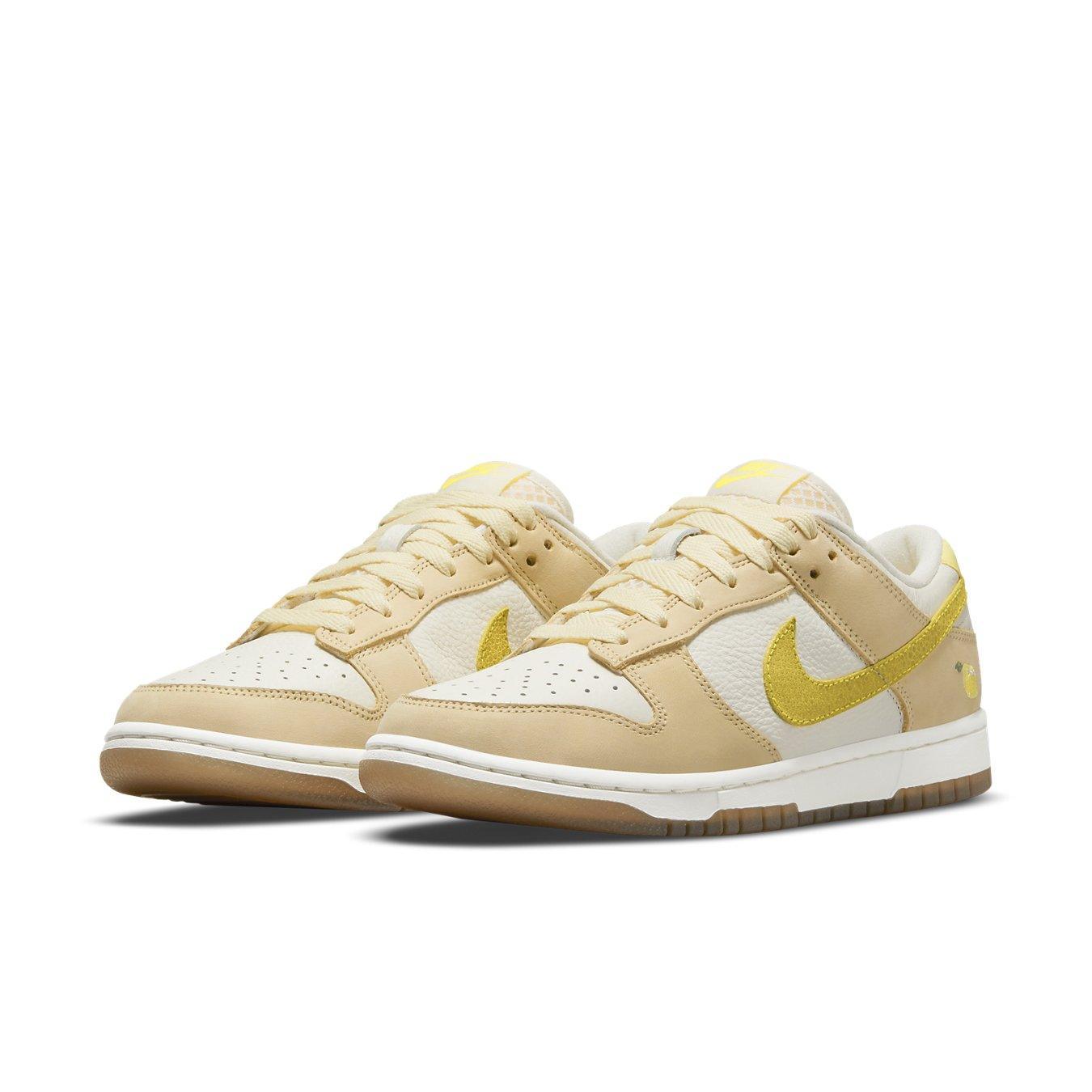 Nike Dunk Low Lemon Drop sneakers in beige and yellow, featuring premium leather and a lemon embroidered on the heel.