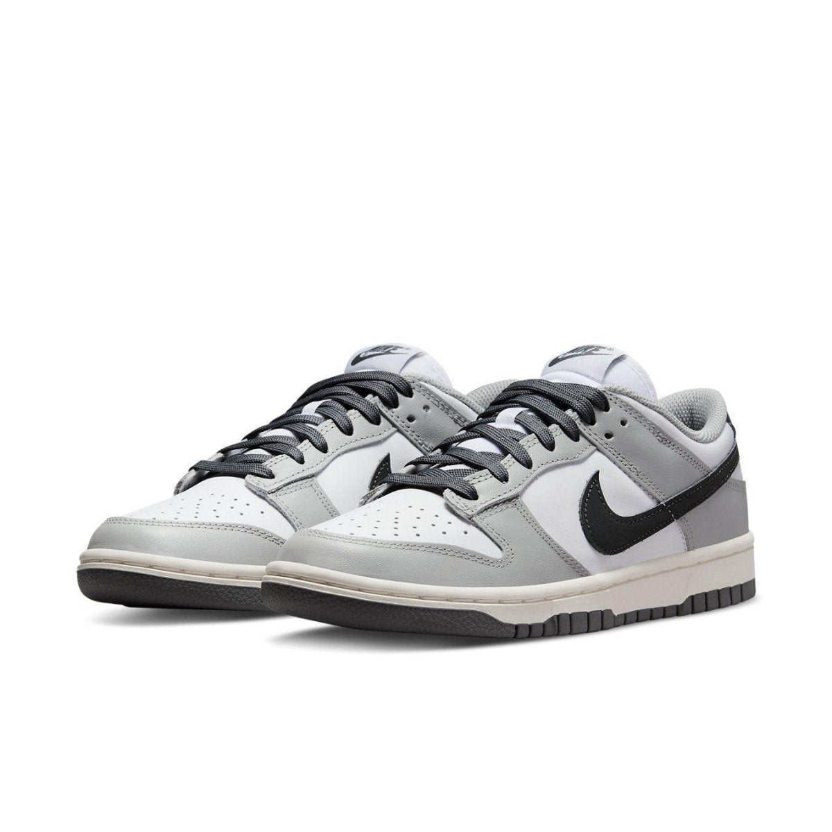 Nike Dunk Low Light Smoke Grey women's sneakers with black Swoosh and gray accents on a white leather base.