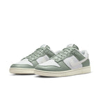 Nike Dunk Low Mica Green sneakers featuring a white and green colorway with vintage canvas details.