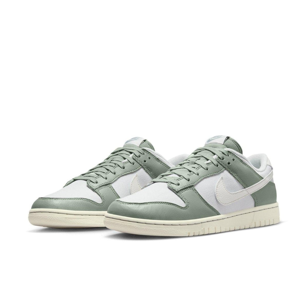 Nike Dunk Low Mica Green sneakers featuring a white and green colorway with vintage canvas details.