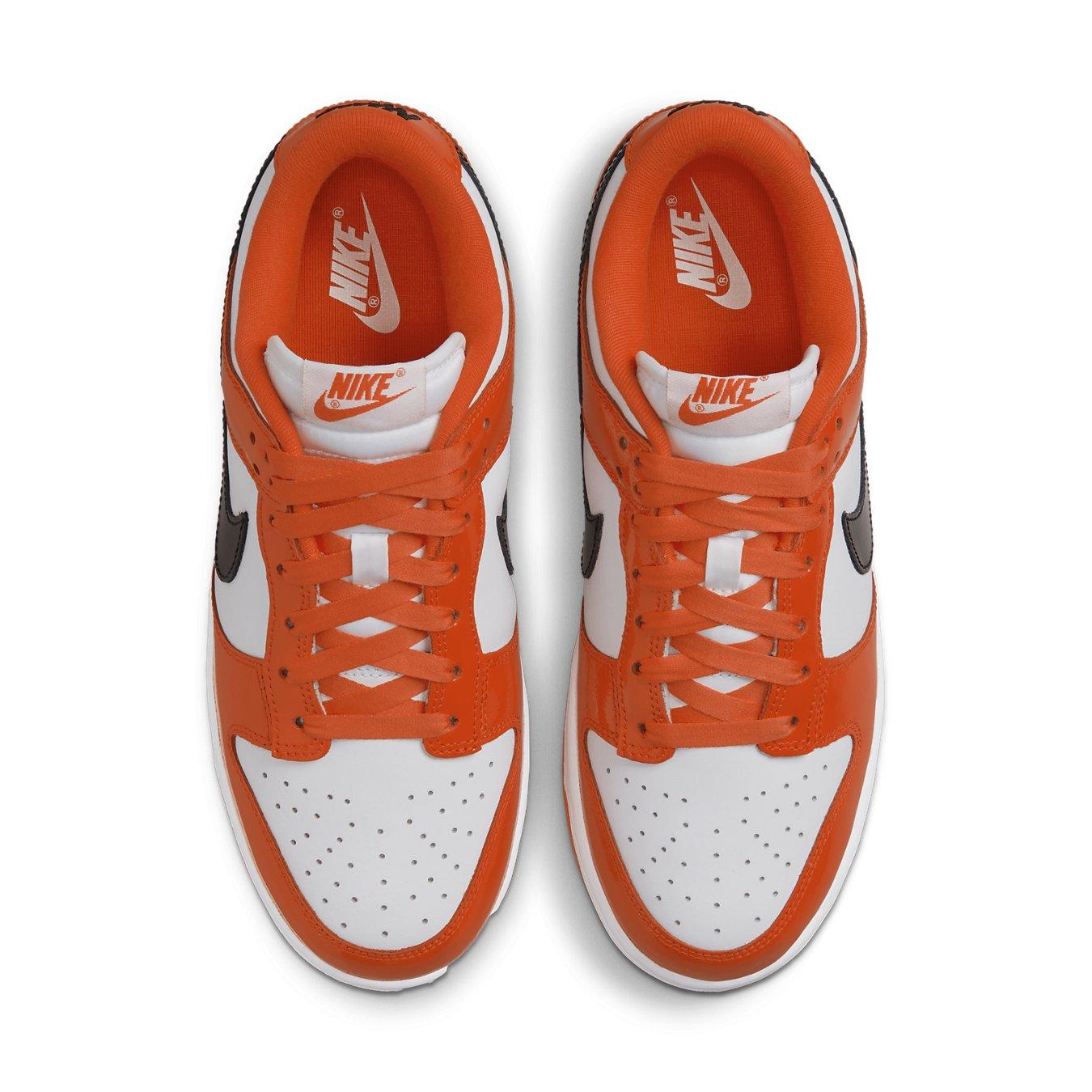 Nike Dunk Low Patent Halloween (W) sneakers with white and orange patent leather, featuring black Swoosh logo.