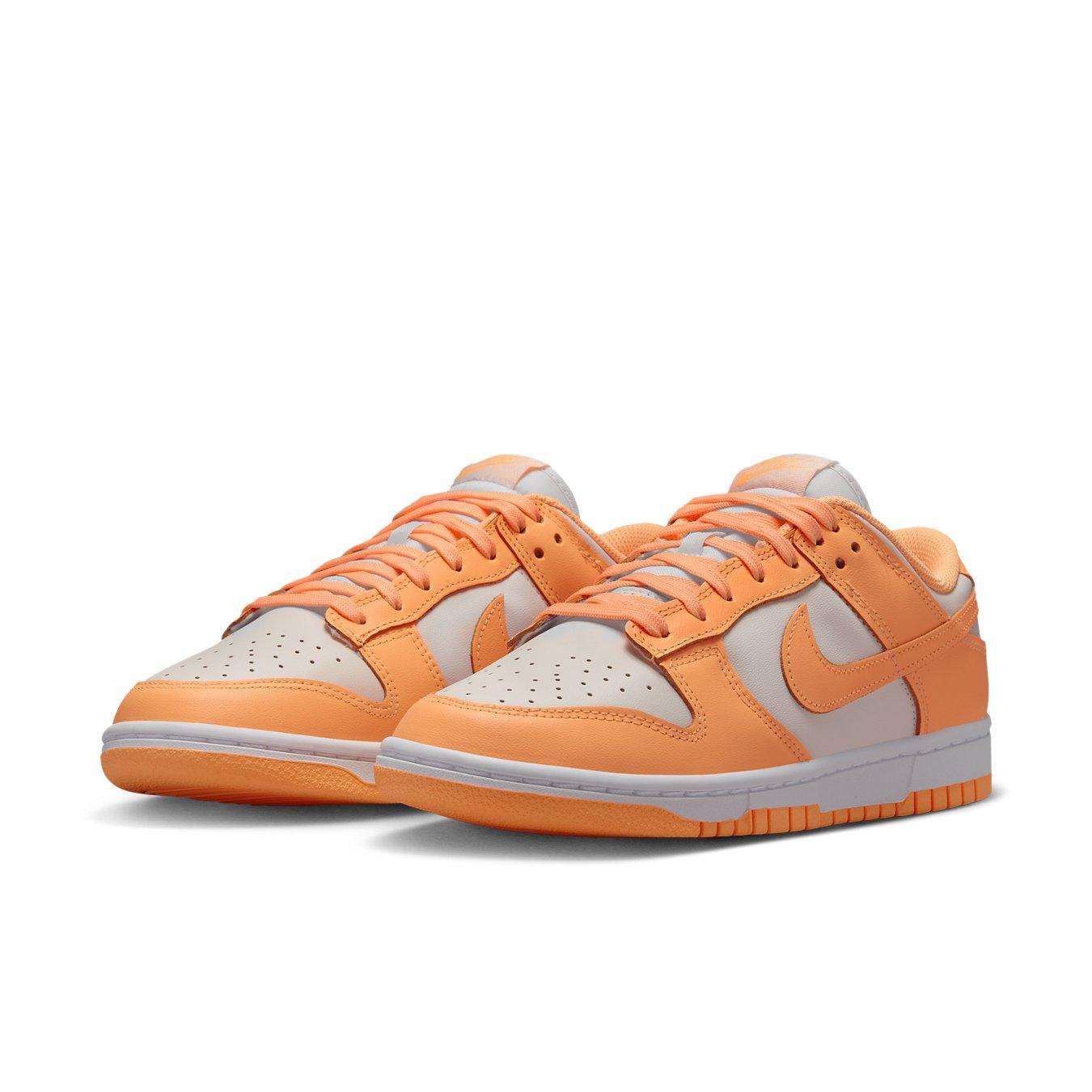 Nike Dunk Low Peach Cream (W) featuring white base, peach Swooshes, laces, and durable sole.