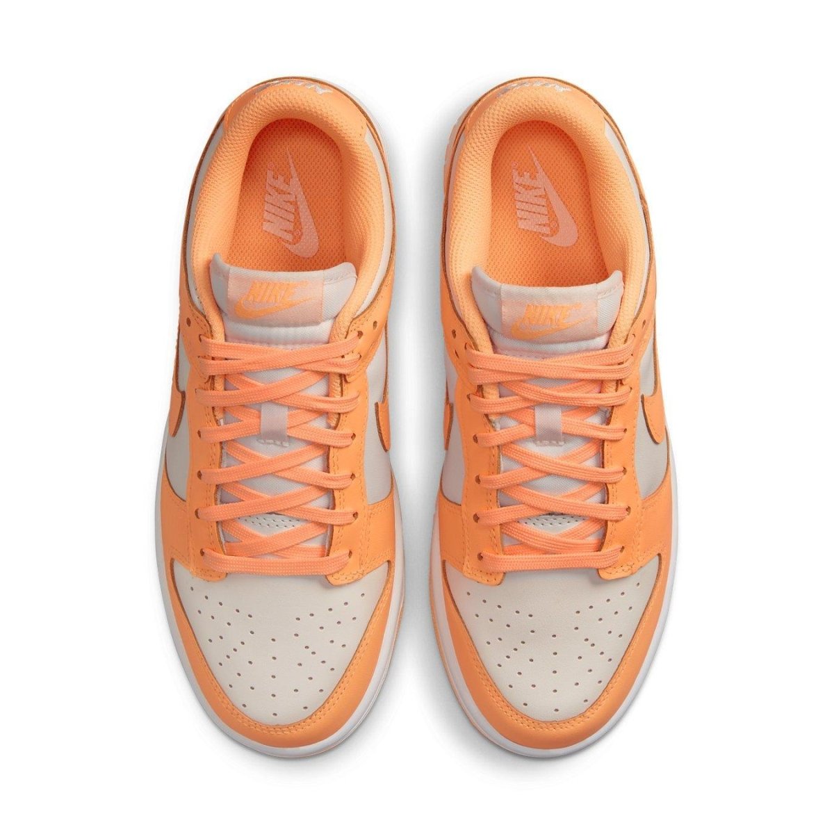 Nike Dunk Low Peach Cream sneakers featuring a white base and vibrant peach details including laces and Swooshes.