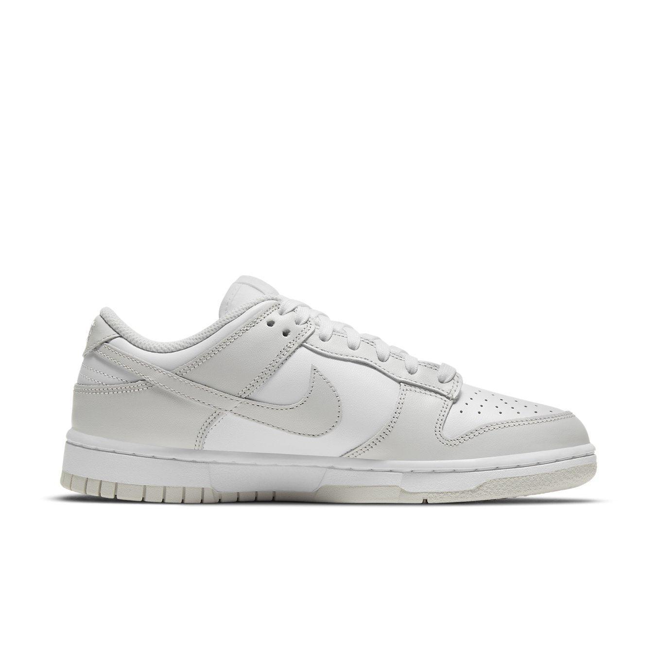 Nike Dunk Low Photon Dust women’s sneaker in gray and white, featuring iconic design and sporty elegance.