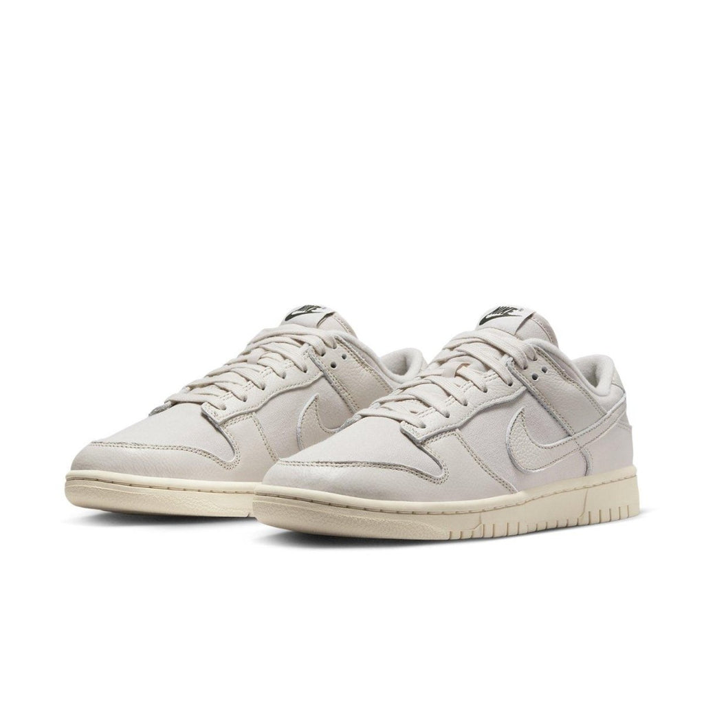 Nike Dunk Low Premium Light Orewood Brown sneakers in light ivory with leather overlays and classic branding.
