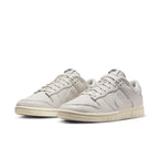 Nike Dunk Low Premium Light Orewood Brown sneakers in light ivory with leather overlays and classic branding.
