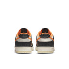 Rear view of Nike Dunk Low PRM Halloween sneakers featuring black and white panels with vibrant orange accents.