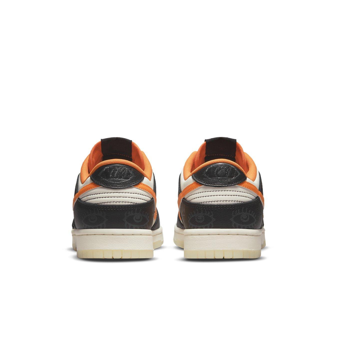 Rear view of Nike Dunk Low PRM Halloween sneakers featuring black and white panels with vibrant orange accents.