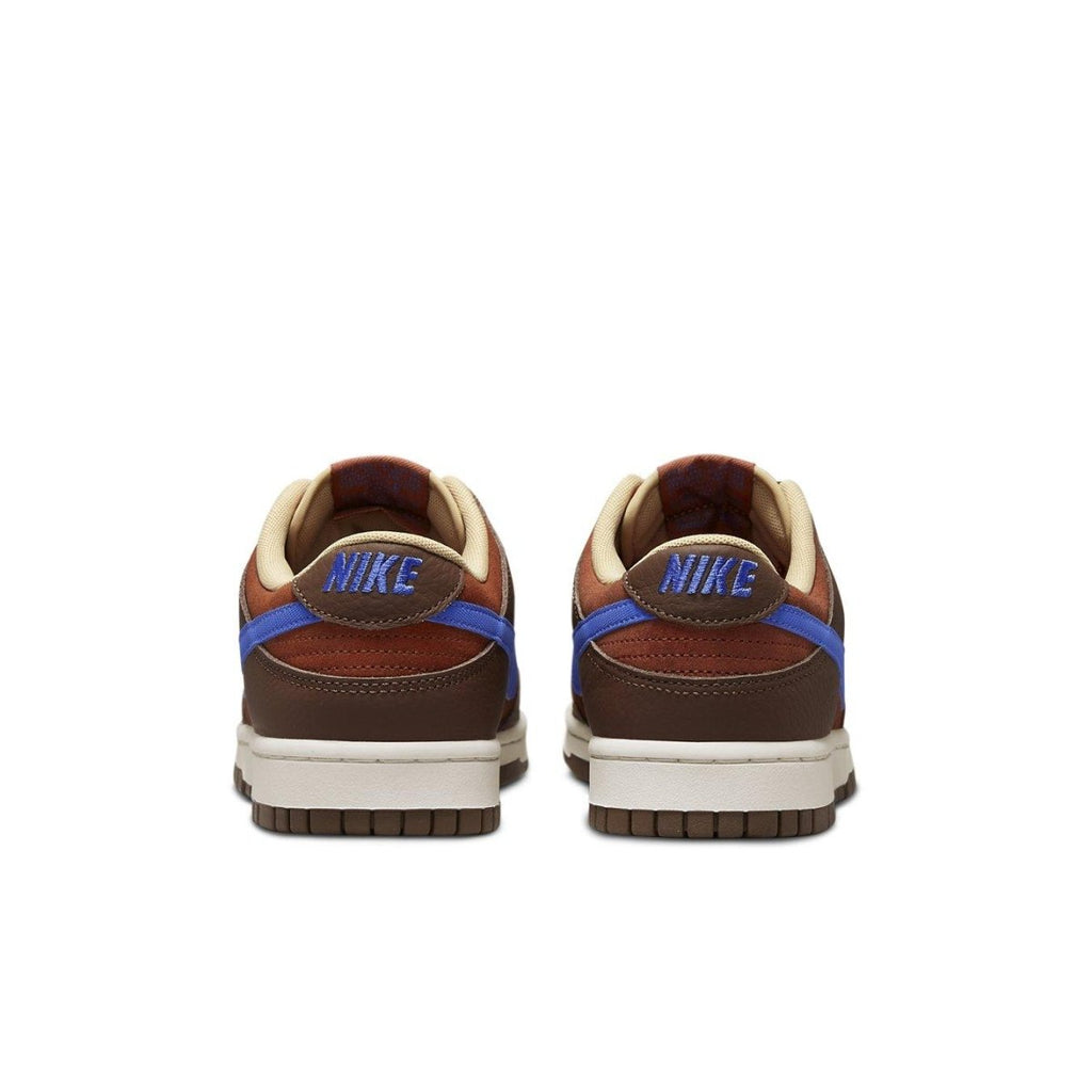 Nike Dunk Low Retro PRM Mars Stone sneakers, featuring rust suede, brown leather, and blue Swoosh at the back.