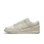 Nike Dunk Low Sail Light Bone sneakers in a light beige colorway, featuring a sleek leather design and classic silhouette.