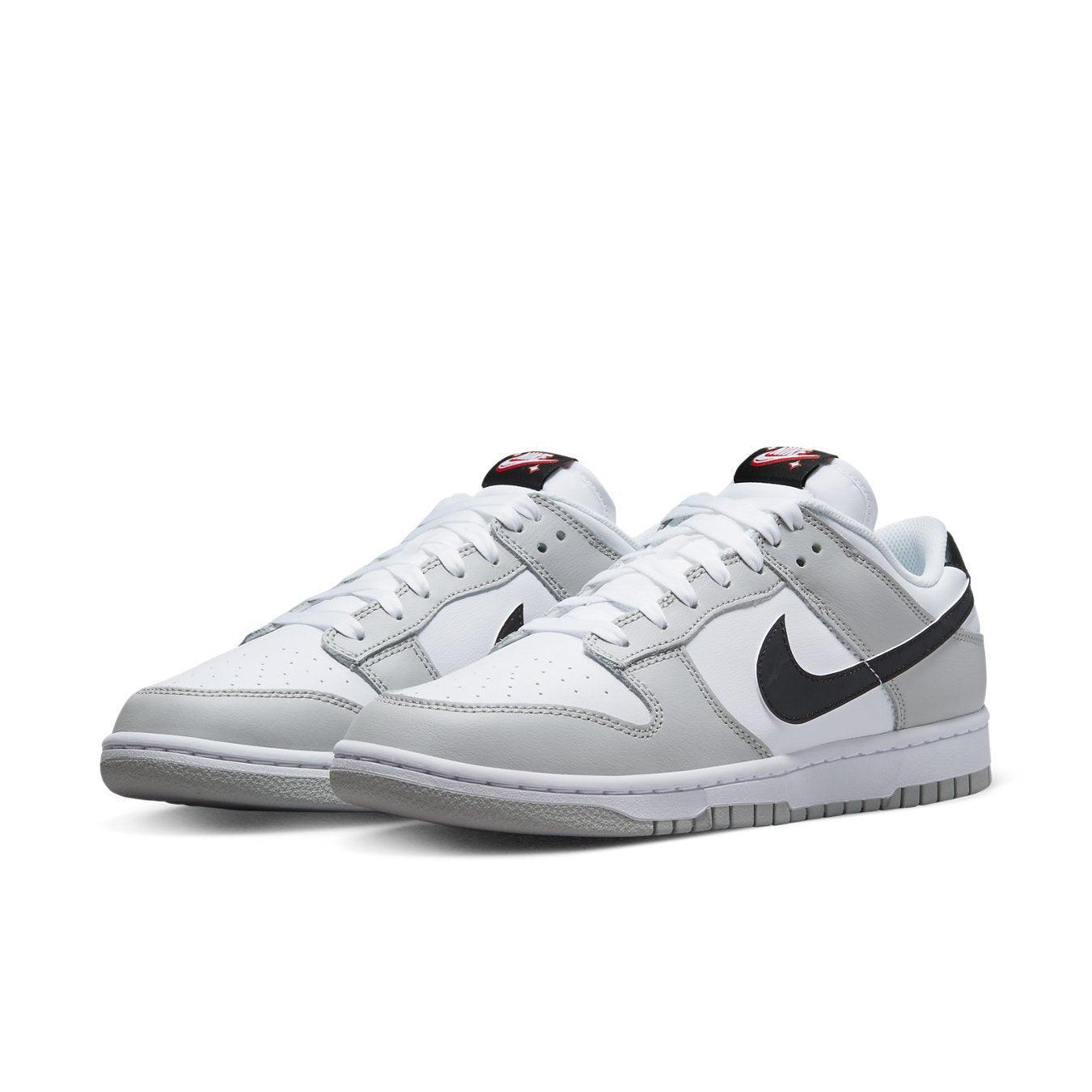Nike Dunk Low SE Lottery Pack in Grey Fog with black Swoosh, white leather upper, and contrasting details.