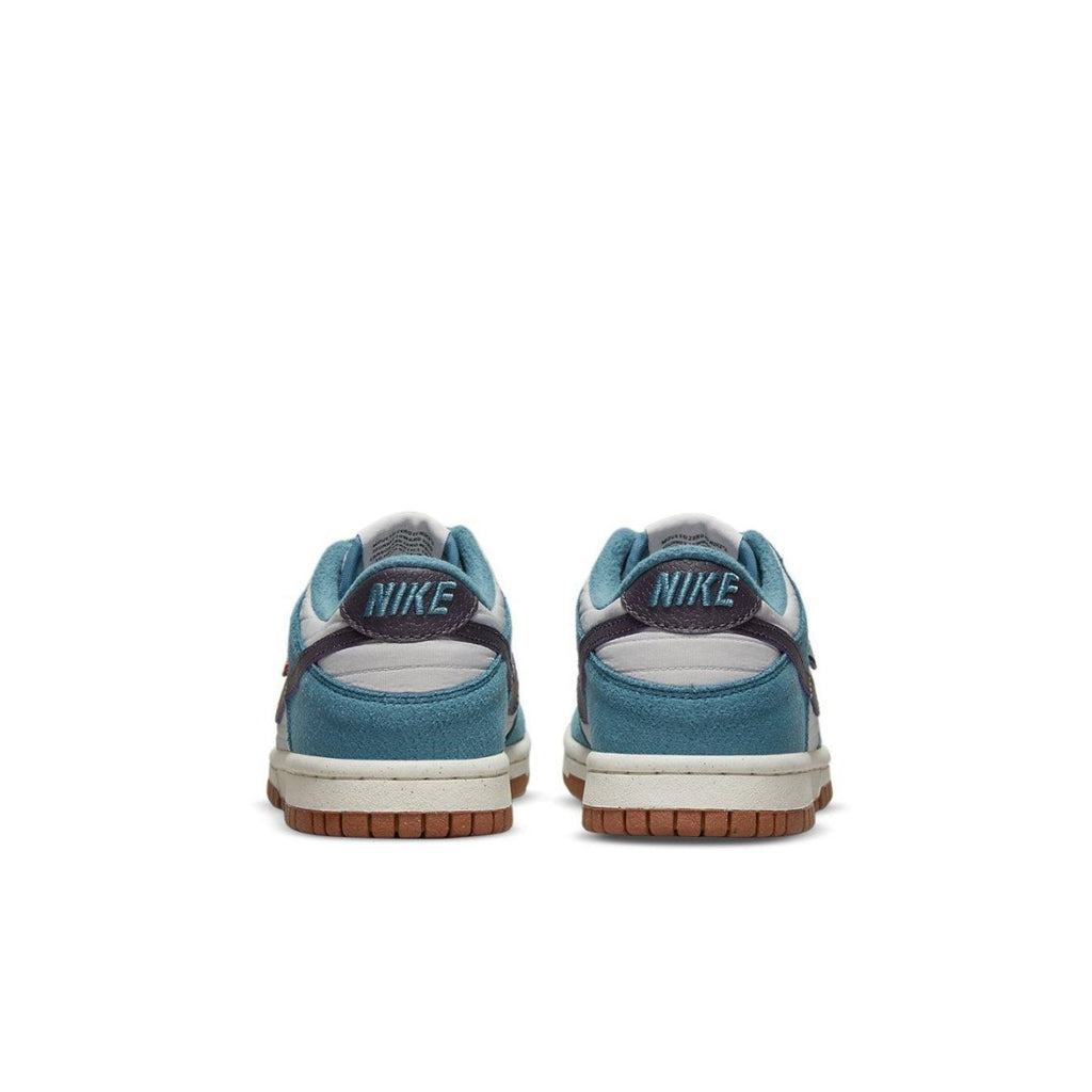 Nike Dunk Low SE Toasty Rift Blue GS sneakers, showing the back view with blue suede and Nike logo on the heel.