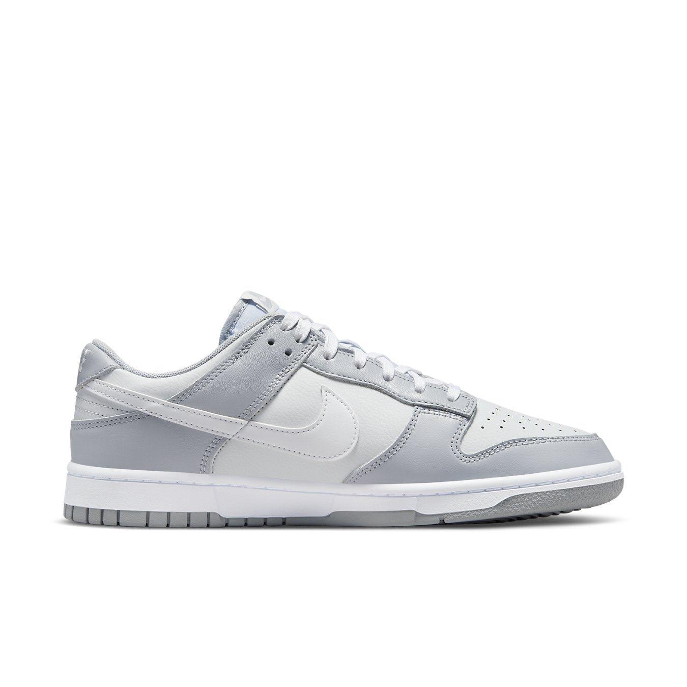 Nike Dunk Low Two Tone Grey sneakers in white leather with grey overlays and white Swoosh, showcasing modern style.