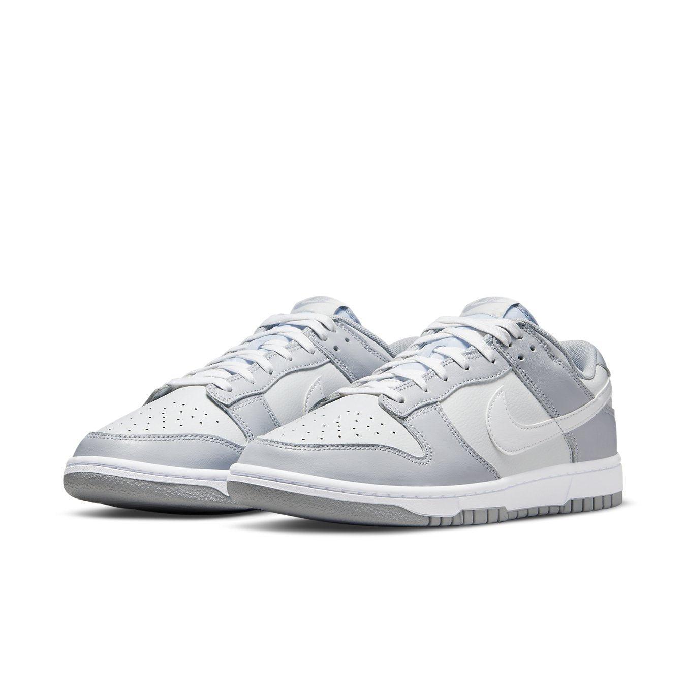 Nike Dunk Low Two Tone Grey sneakers in white leather with gray overlays on eyelets, fender, and heel.