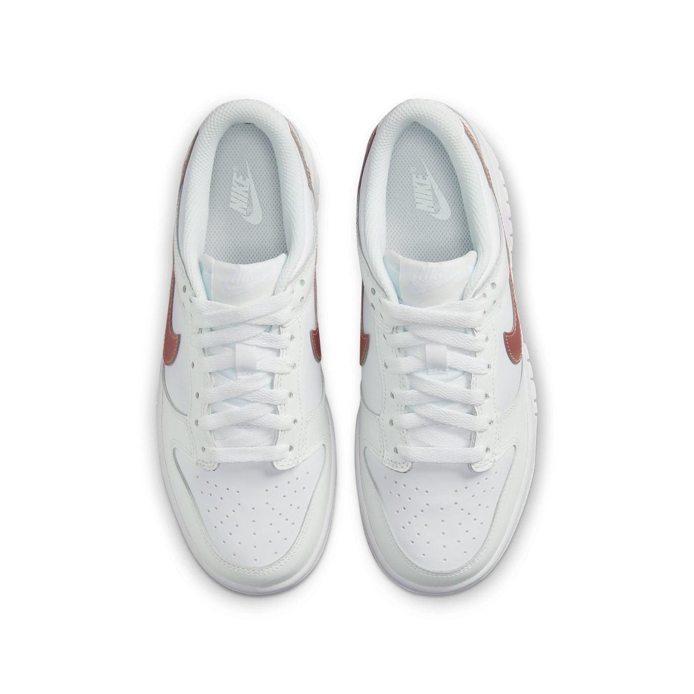 Nike Dunk Low White Pink (GS) sneakers with a white leather upper and bronze Swoosh detail from above.