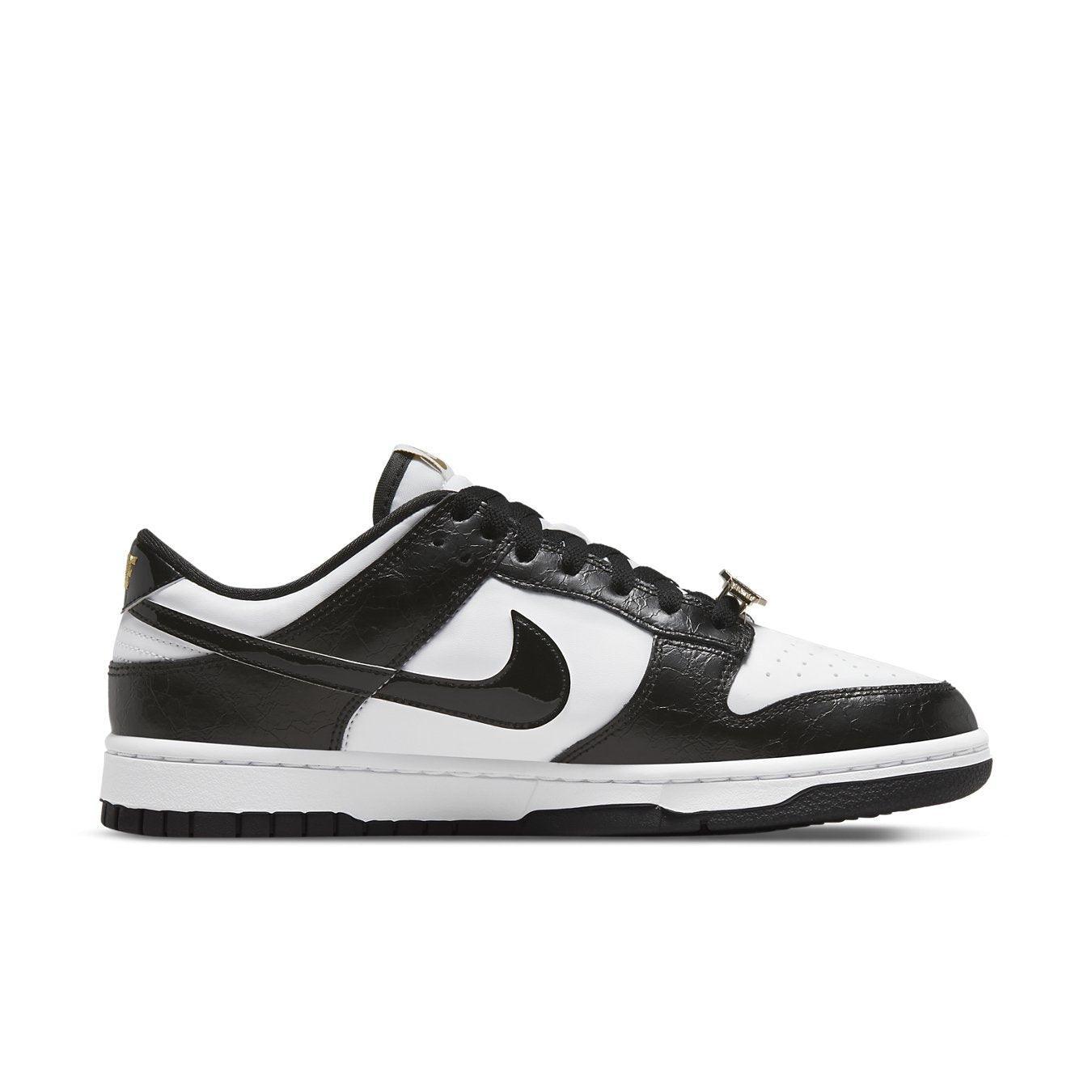 Nike Dunk Low World Champs in black and white with gold accent details, featuring a luxurious design.