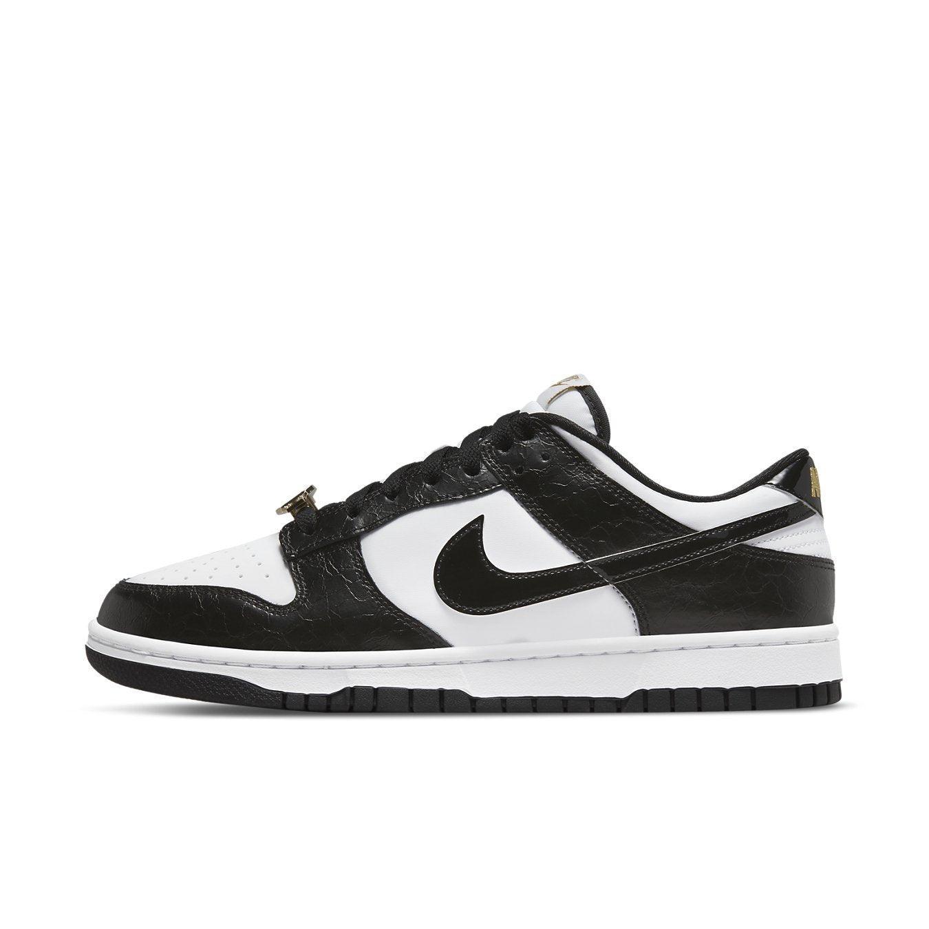 Nike Dunk Low World Champs in black and white with glossy overlays and gold accents, side view.