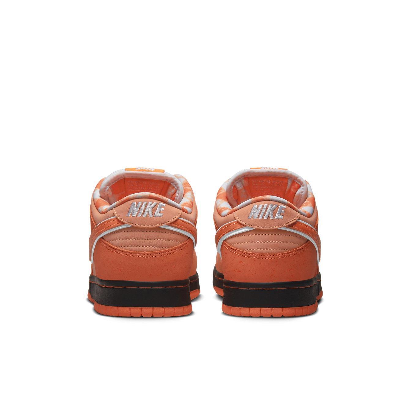Back view of Nike SB Dunk Low Concepts Orange Lobster sneakers showcasing vibrant orange suede and white branding.