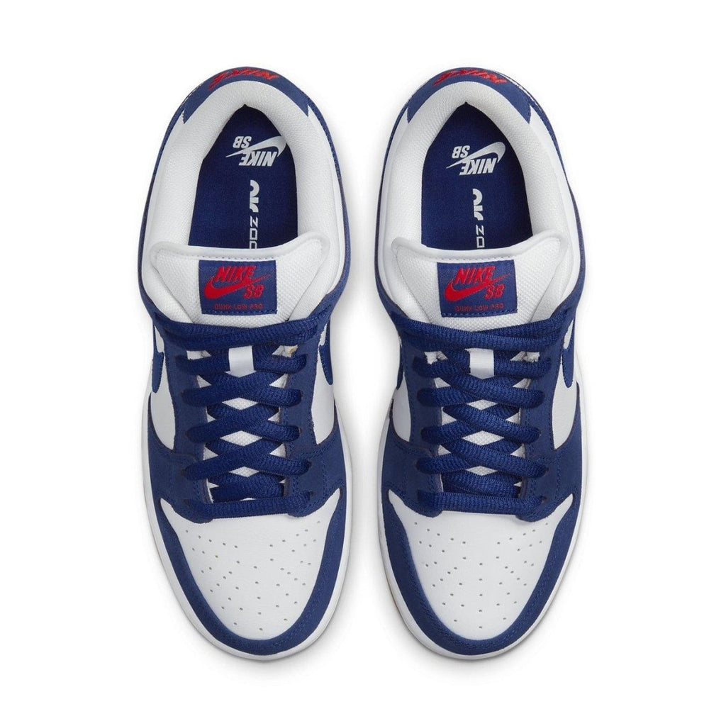 Nike SB Dunk Low in Deep Royal Blue and White with red accents on tongue and classic design.