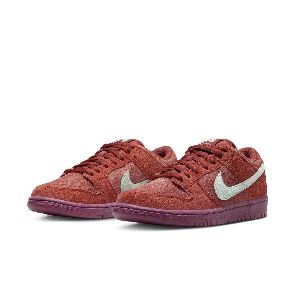 Nike SB Dunk Low Mystic Red shoes featuring soft suede upper and Emerald Rise accents on the Swoosh.