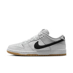 Nike SB Dunk Low Pro White Gum sneakers featuring white leather and black Swoosh logo, side view.