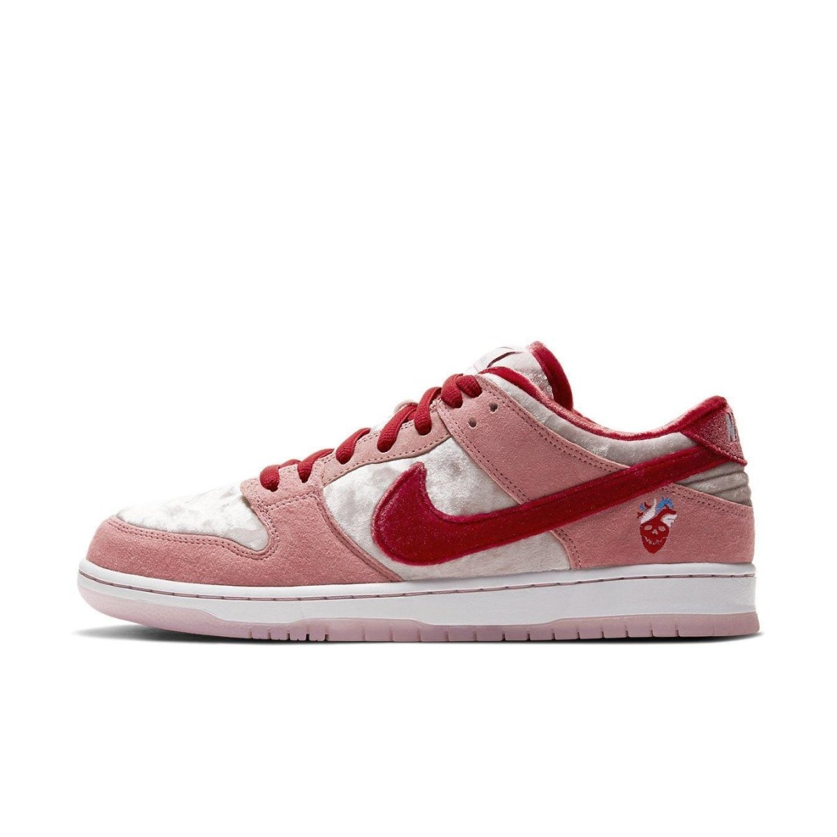 Nike SB Dunk Low StrangeLove Skateboards in pink and red, featuring suede overlays and a unique texture design.