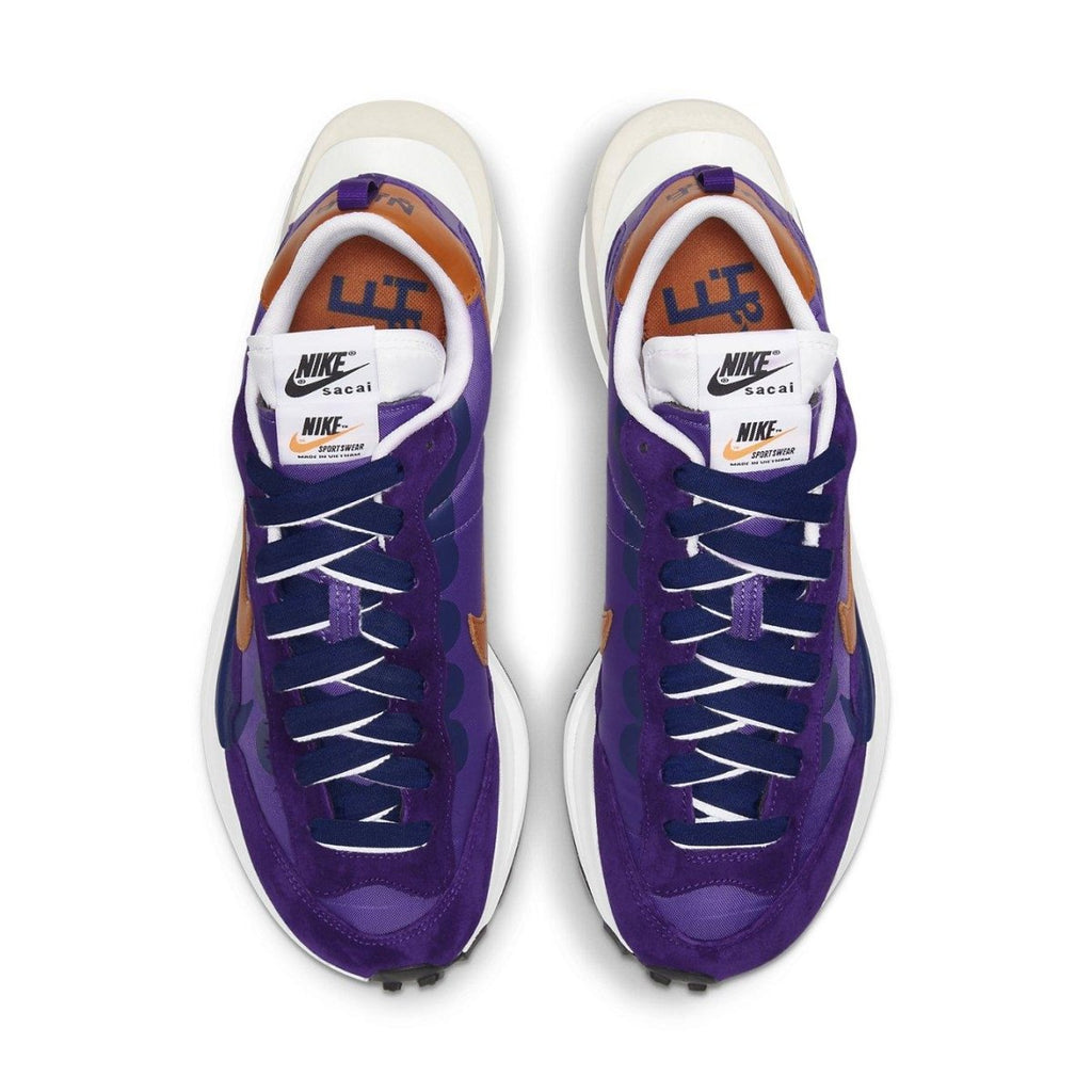 Nike Vaporwaffle sacai Dark Iris sneakers in purple with orange accents, featuring a retro-inspired design.